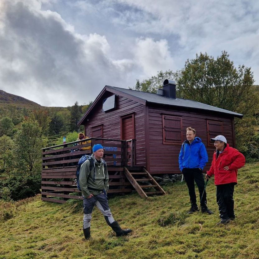 Turkledde folk i naturen utenfor hytte